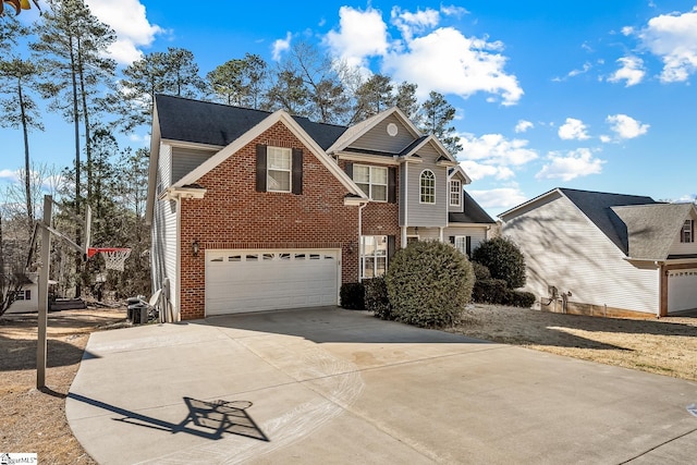 traditional-style home with a garage, driveway, and brick siding