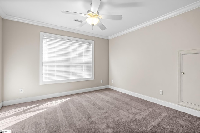 carpeted empty room featuring baseboards, visible vents, a ceiling fan, and crown molding