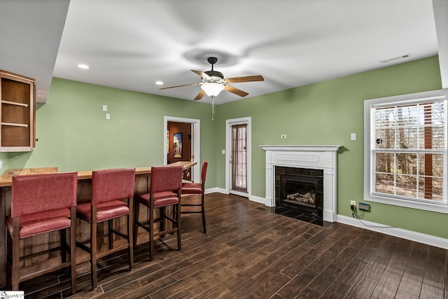 interior space featuring a bar, dark wood-style flooring, visible vents, and baseboards