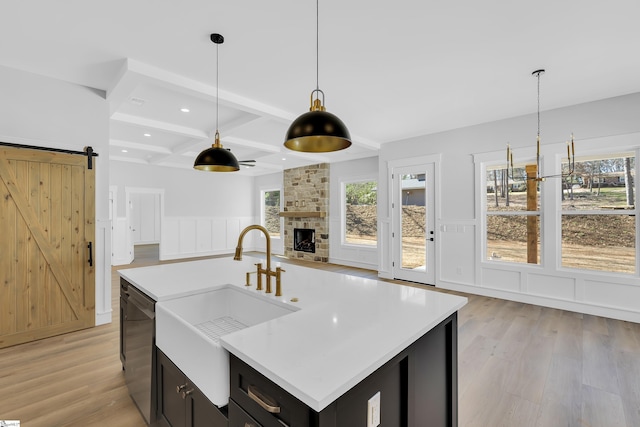 kitchen featuring a barn door, a sink, coffered ceiling, beamed ceiling, and dishwasher