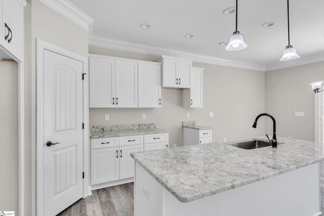 kitchen featuring ornamental molding, white cabinets, and a sink