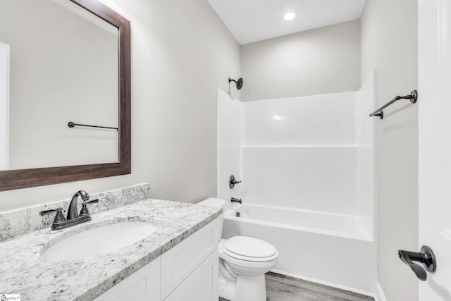 bathroom with vanity, shower / washtub combination, wood finished floors, and toilet