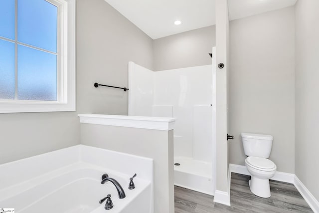 bathroom with toilet, a bath, wood finished floors, baseboards, and walk in shower