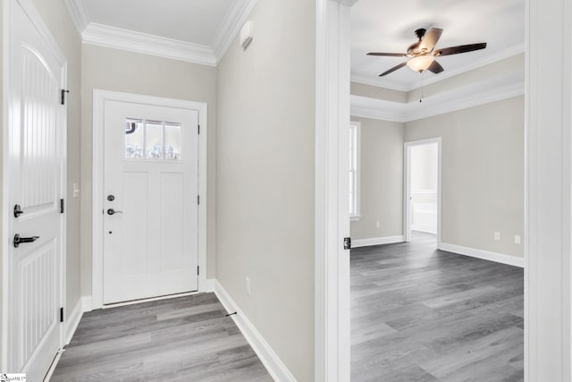 foyer with a ceiling fan, crown molding, baseboards, and wood finished floors