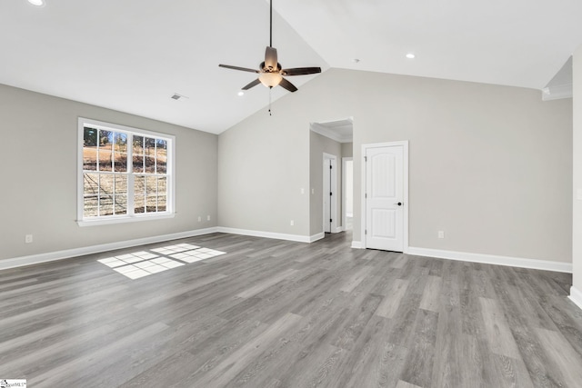 interior space with visible vents, a ceiling fan, wood finished floors, high vaulted ceiling, and baseboards