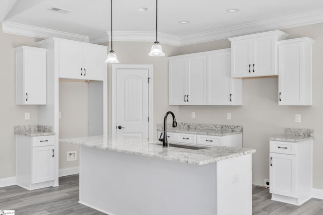 kitchen featuring light wood-type flooring, crown molding, white cabinetry, and a sink