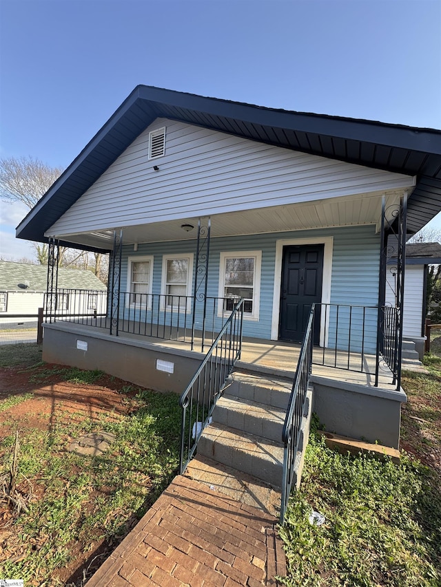 view of front facade with covered porch and crawl space