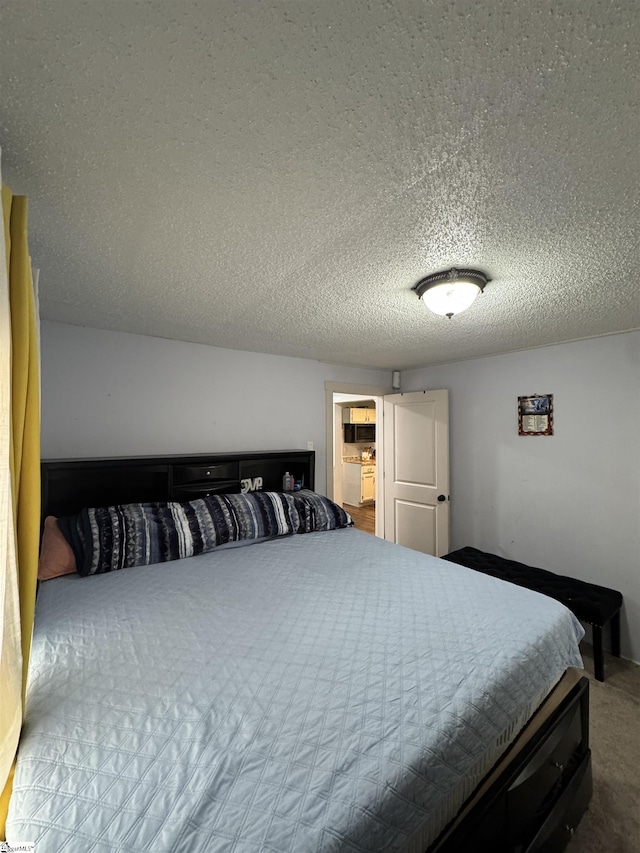 bedroom featuring a textured ceiling and carpet flooring