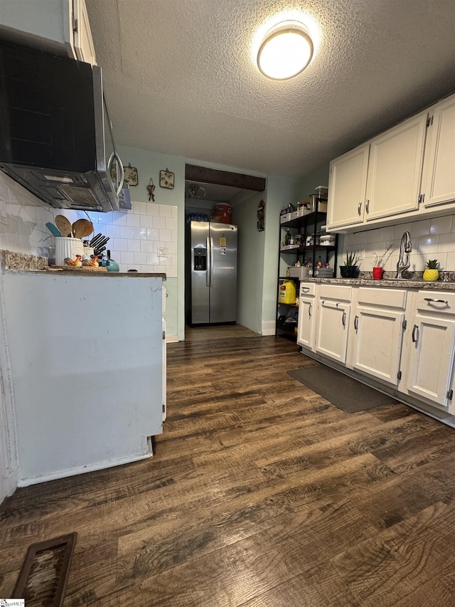 kitchen with white cabinets, backsplash, stainless steel refrigerator with ice dispenser, and dark wood-type flooring