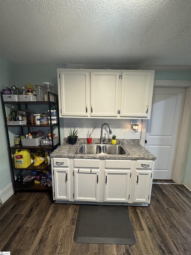 kitchen featuring white cabinetry, dark wood-style flooring, and a sink