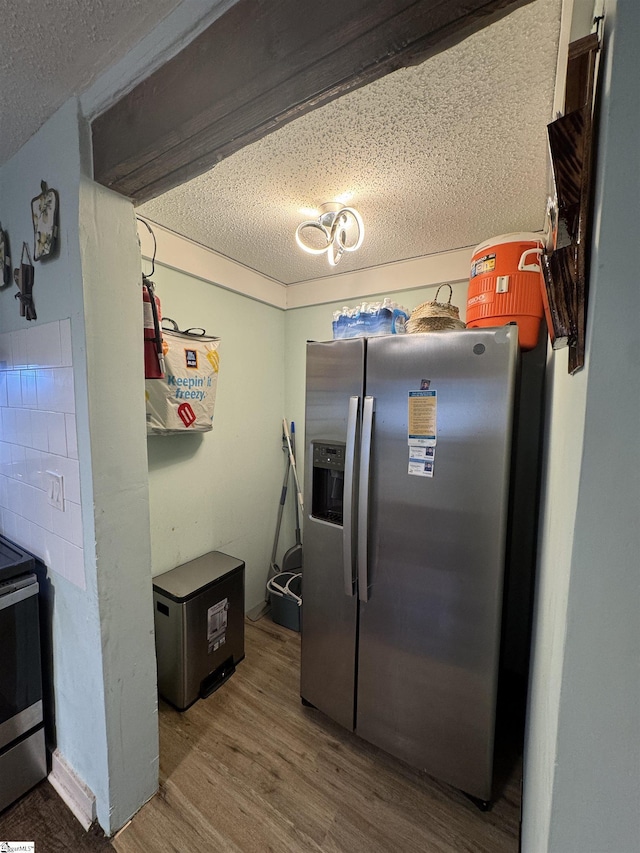 kitchen with a textured ceiling, stainless steel refrigerator with ice dispenser, and wood finished floors