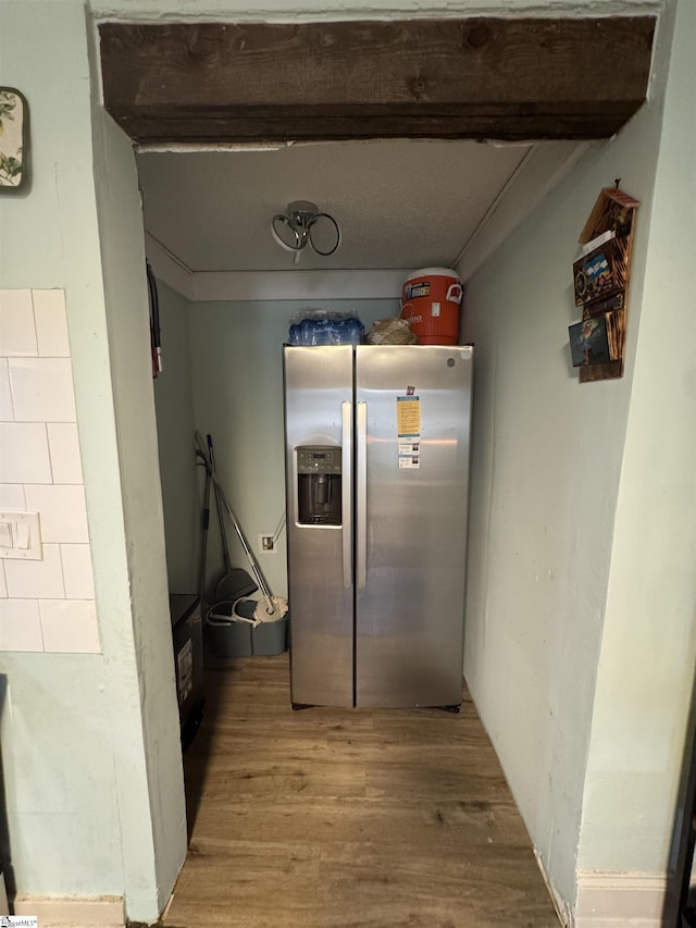 kitchen with beam ceiling, stainless steel fridge, and wood finished floors