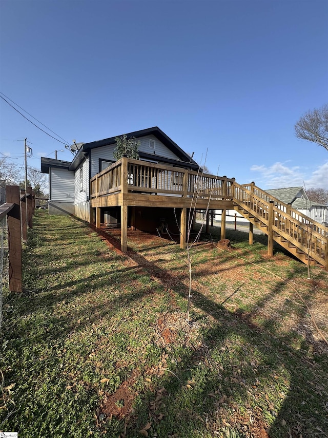 rear view of property with a lawn and a wooden deck