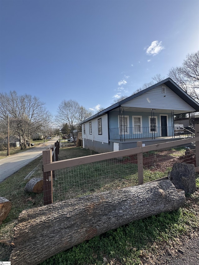 view of property exterior featuring a fenced front yard and covered porch