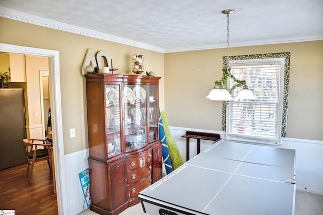 dining space with ornamental molding and wood finished floors