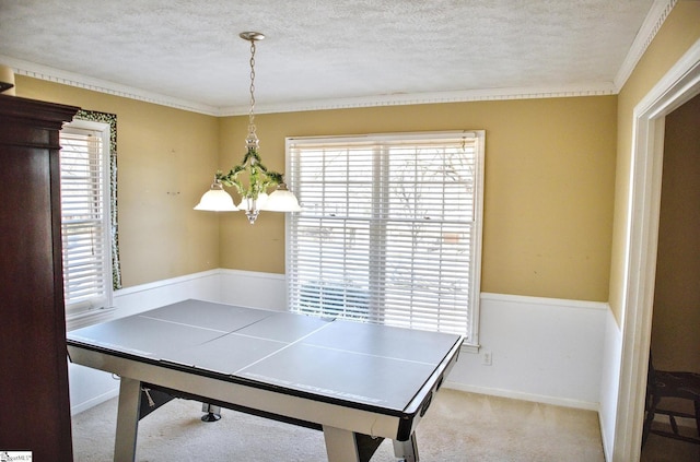 playroom featuring carpet, crown molding, a textured ceiling, and baseboards