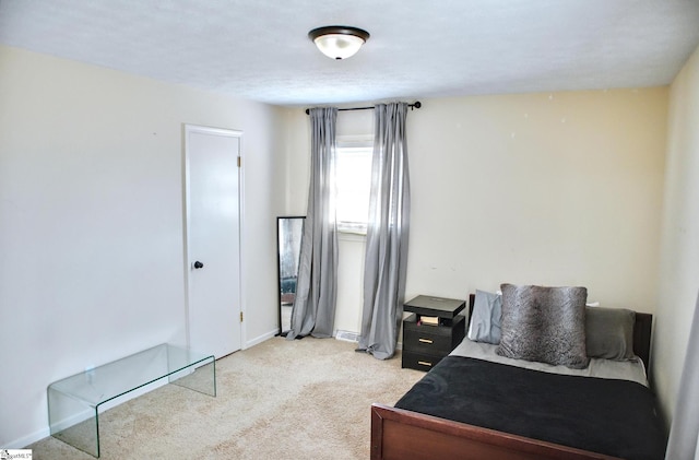 bedroom with baseboards and light colored carpet