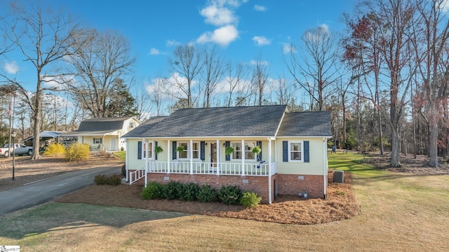 ranch-style house featuring driveway, central AC unit, crawl space, covered porch, and a front yard