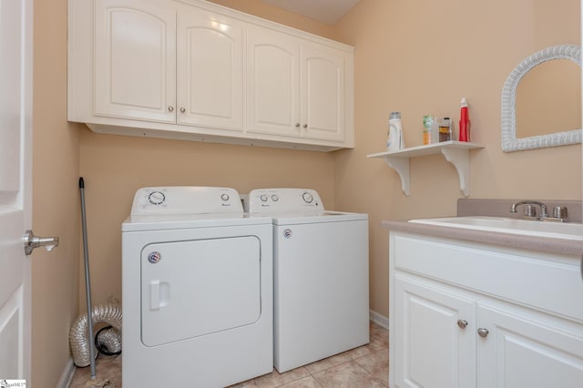 laundry area with a sink, cabinet space, light tile patterned floors, and washer and dryer