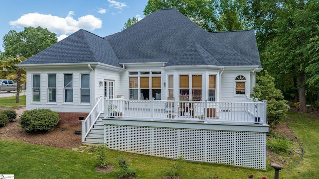 rear view of property with a shingled roof and a deck