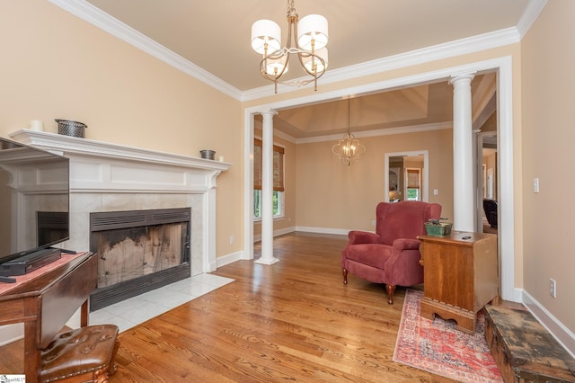 interior space featuring decorative columns, a chandelier, and ornamental molding