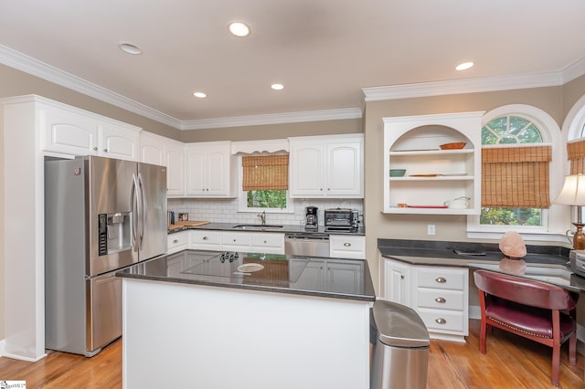 kitchen with stainless steel appliances, light wood-style floors, white cabinets, and a sink