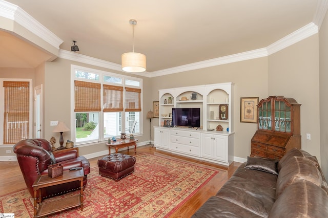 living area featuring ornamental molding, light wood-style flooring, and baseboards