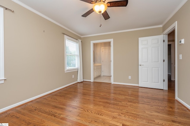 unfurnished bedroom featuring crown molding, baseboards, connected bathroom, and light wood-style floors