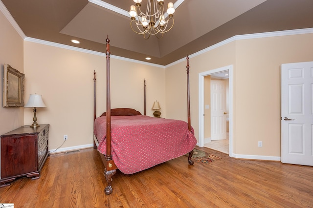 bedroom with a notable chandelier, recessed lighting, wood finished floors, baseboards, and ornamental molding