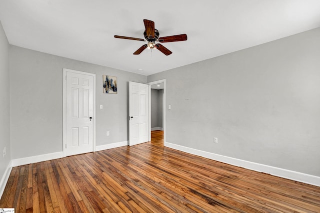 unfurnished bedroom with wood-type flooring, ceiling fan, and baseboards