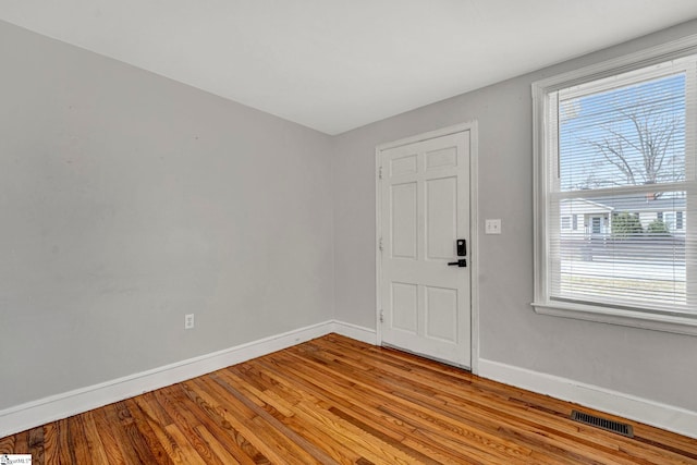 entryway featuring baseboards, visible vents, and wood finished floors