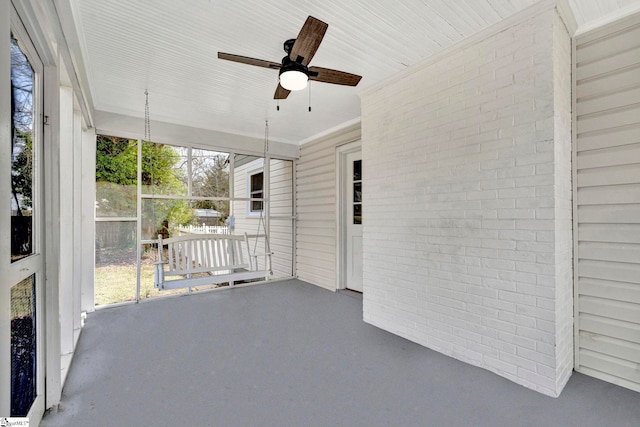 unfurnished sunroom featuring ceiling fan