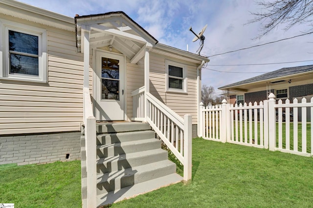 entrance to property with fence and a lawn