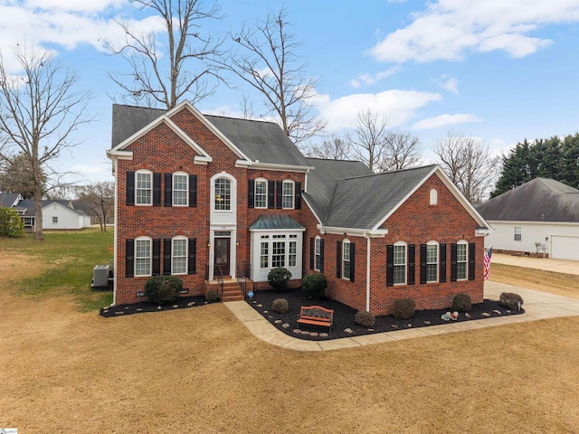 view of front facade with a front yard, crawl space, brick siding, and central AC