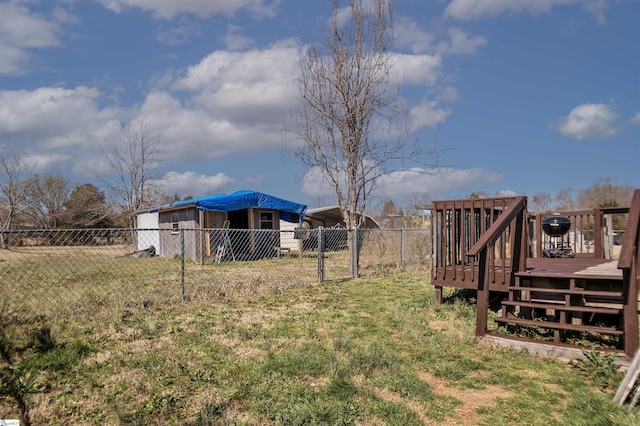 view of yard featuring a carport, a gate, fence, and a wooden deck