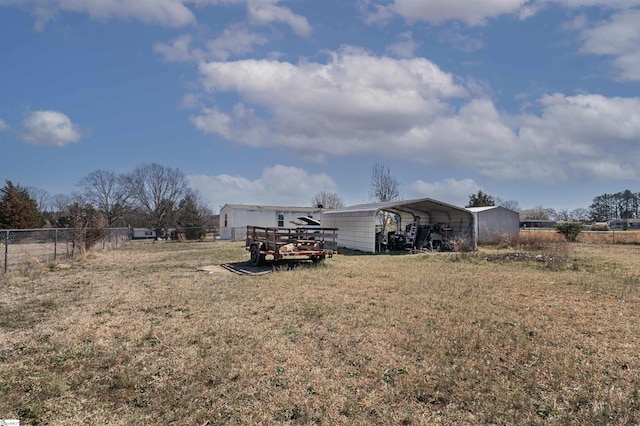 view of yard featuring fence and a detached carport