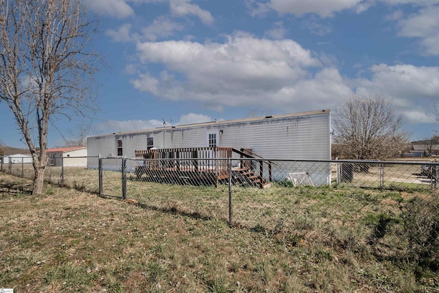 back of property featuring a yard, fence, and a wooden deck