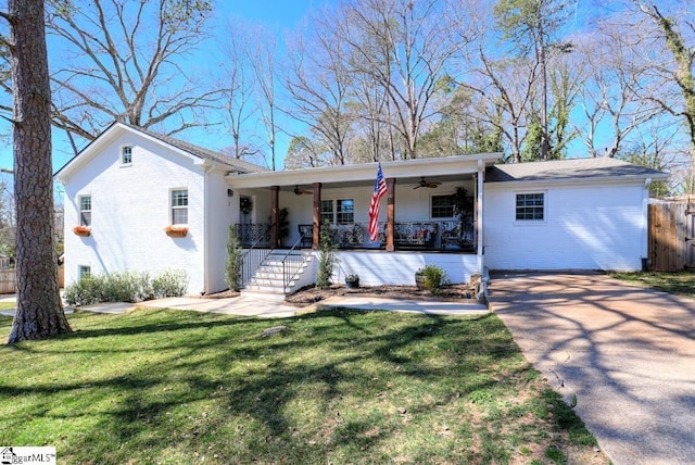 single story home featuring ceiling fan, brick siding, covered porch, and a front yard