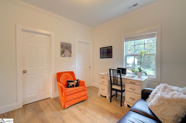 home office featuring light wood-type flooring, visible vents, and ornamental molding