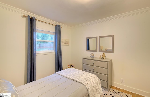 bedroom with ornamental molding, light wood-style flooring, and baseboards