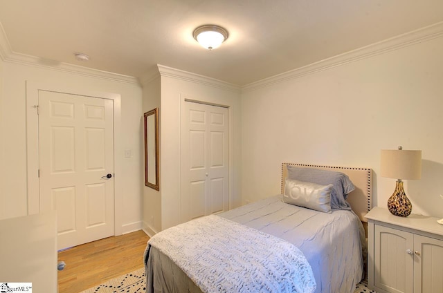 bedroom with ornamental molding, a closet, and light wood-style flooring