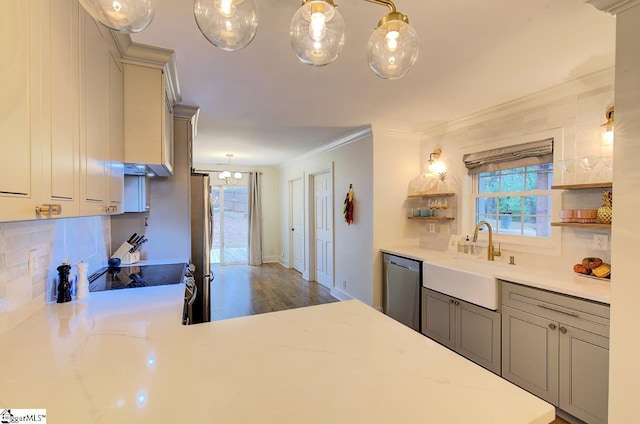 kitchen featuring light stone counters, stainless steel appliances, a sink, backsplash, and crown molding