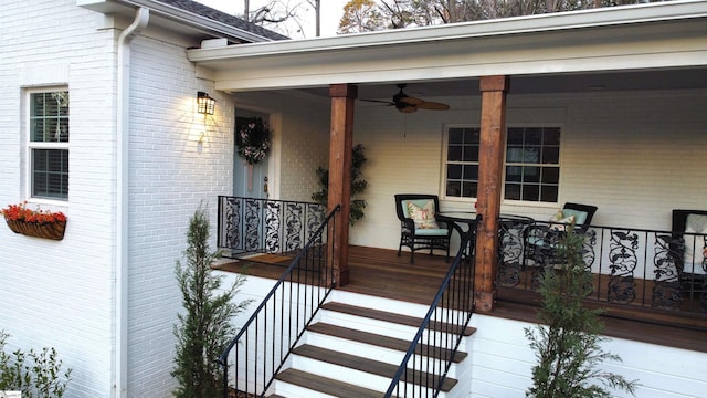 view of exterior entry with brick siding and ceiling fan