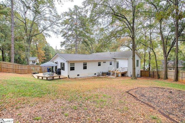 rear view of house featuring crawl space, a fenced backyard, a lawn, and a wooden deck