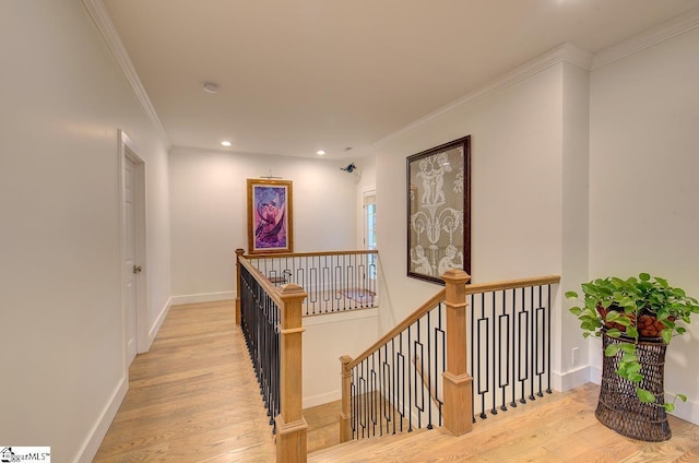 hall with baseboards, ornamental molding, wood finished floors, an upstairs landing, and recessed lighting