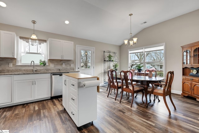 kitchen with vaulted ceiling, stainless steel dishwasher, dark wood-style floors, and visible vents