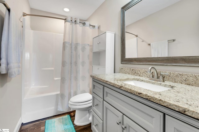 bathroom with toilet, recessed lighting, wood finished floors, vanity, and shower / bath combo