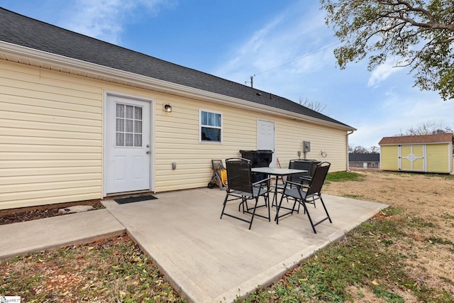 view of patio / terrace with a shed, outdoor dining area, and an outdoor structure