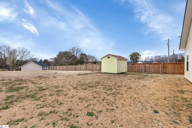 view of yard with a storage shed, a fenced backyard, and an outdoor structure