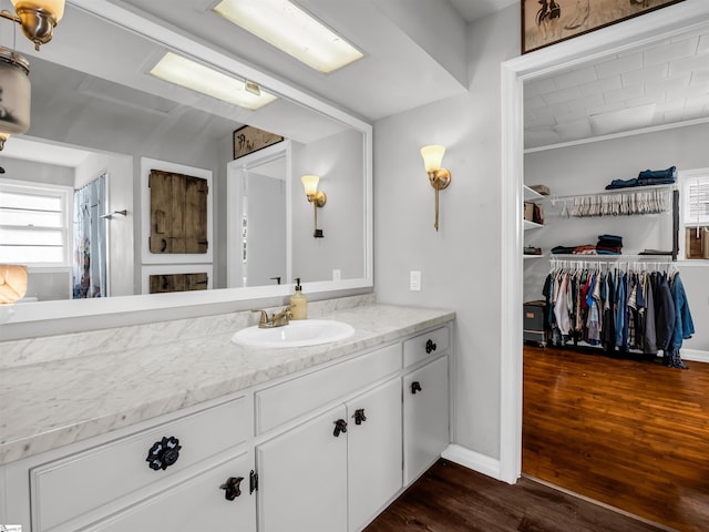 bathroom with wood finished floors, vanity, and baseboards